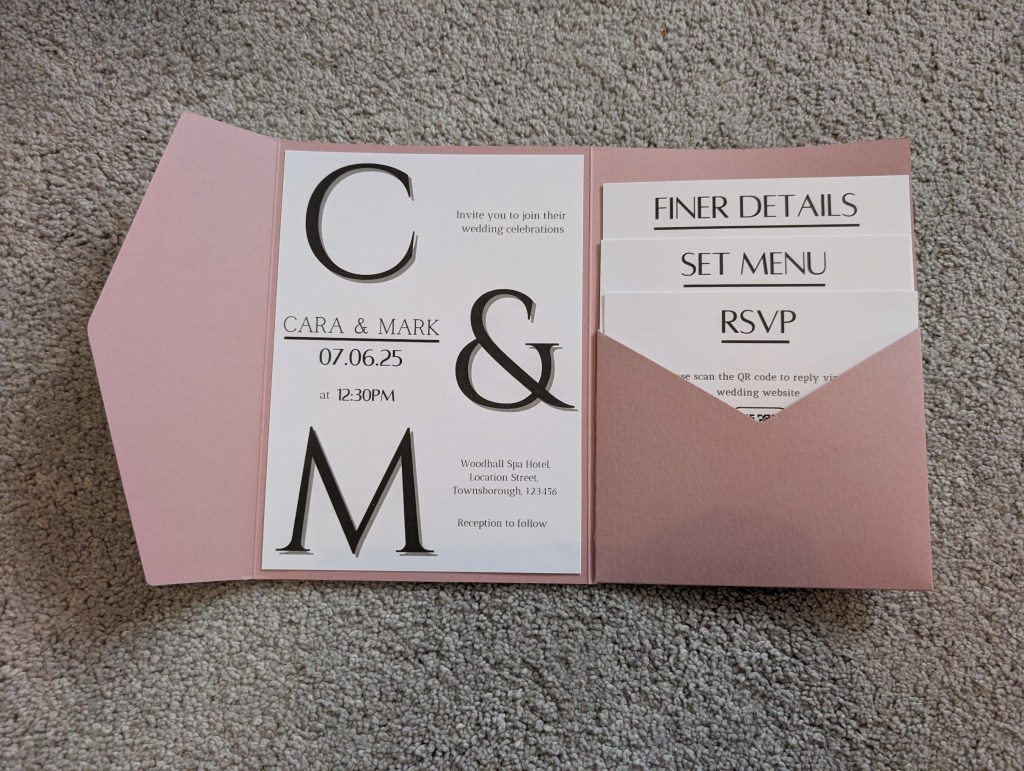 Minimalist monochrome wedding invitation set within dusty pink pocketfold
